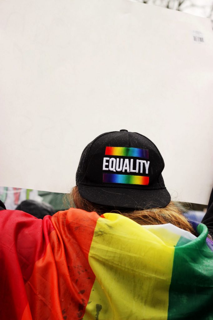 A person at a pride event with a rainbow hat that says equality. Representing lgbtq counseling.