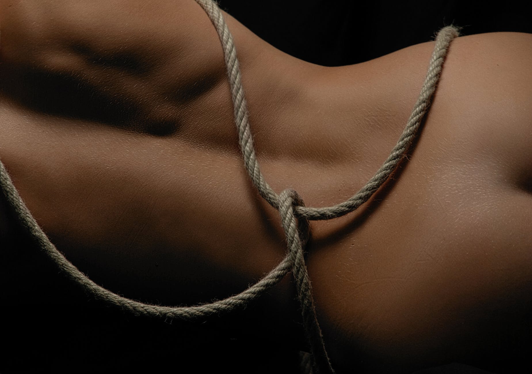 a nude person with rope tied around its body