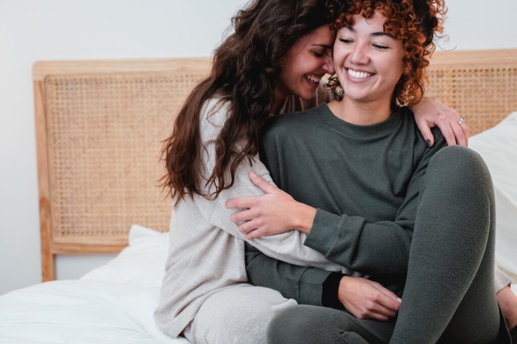 Gay female couple having tender moment in bed at home - Lgbt lesbian concept