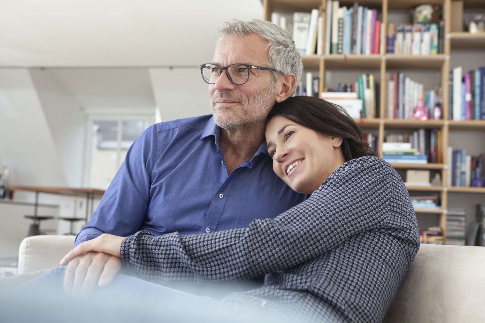 Smiling mature couple cuddling at home