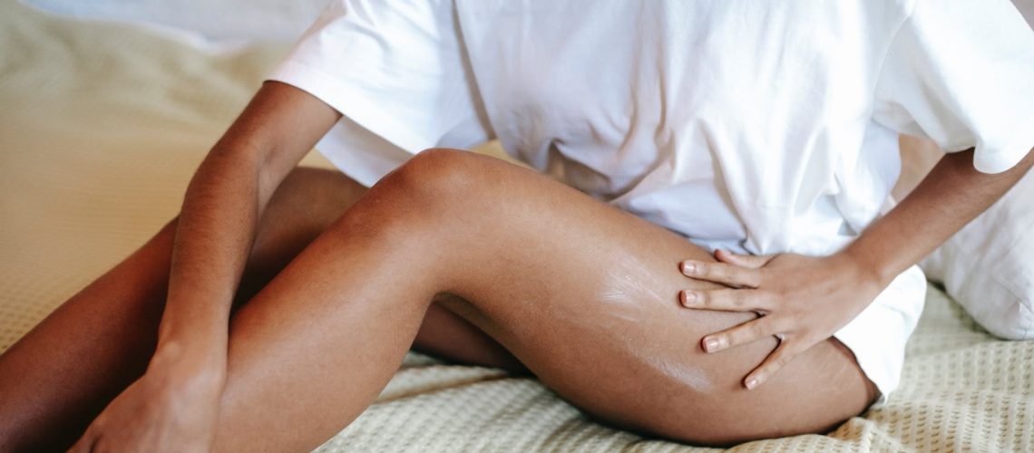 woman massaging leg with cream